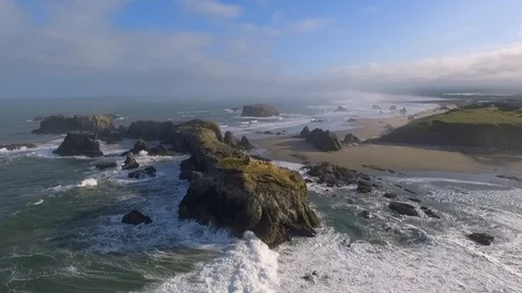 Large ocean waves crash over seagull nesting sea stack rock formations Stock Footage 119661200