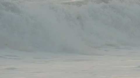 Large ocean waves with white foam crashing on a sandy beach Vídeo Stock 343555339