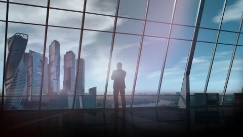 In a large office, against the window, a man stands and looks into the distance. Stock Illustration