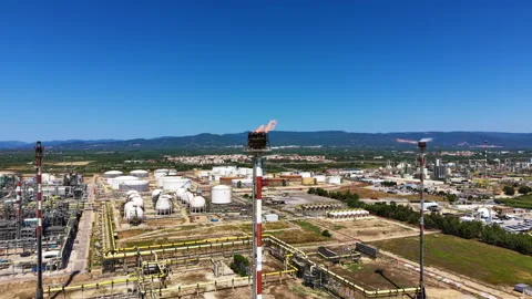 Large oil refinery complex with flare stack burning gas, storage tanks Stock Footage 345426327