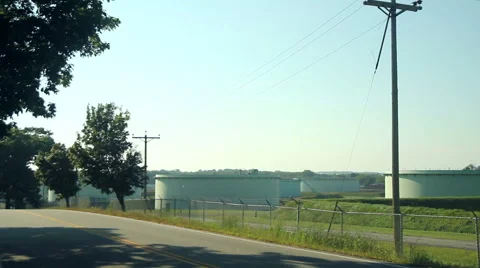Large oil tanks at sunset, camera pan right, wide shot Stock Footage 41511408