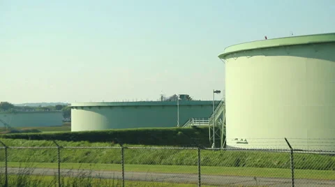 Large oil tanks at sunset, camera pan right, medium shot Stock Footage 41518948