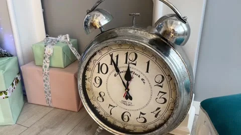 A large old alarm clock stands in the New Year's decorations and shows the time. Stock Footage 228868199