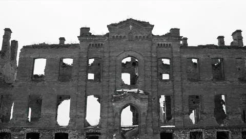A large old ruin with broken windows and empty doors shows signs of decay in Stock Photos