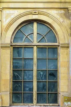 Large old window with arched top and dirty glass Stock Photos