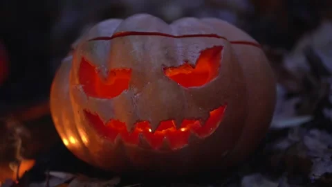 Large one Jack-o-Lantern pumpkin head with burning candle inside on the ground Stock Footage 139201669