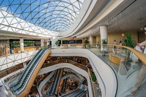 Large, open atrium with curved forms, multiple ascending escalators against.. 写真素材