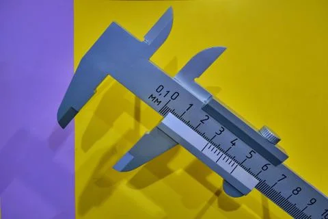 A large open caliper on a background of yellow wall, close-up Stock Photos