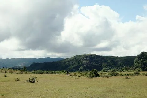 A large, open field with a cloudy sky in the background Stock Photos