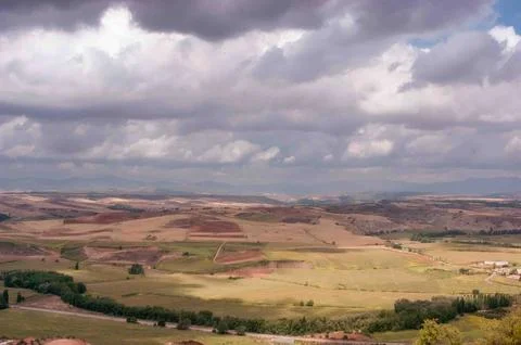 A large, open field with a cloudy sky in the background Stock Photos