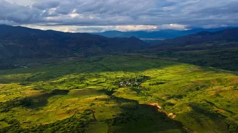 A large, open field with a mountain range in the background Stock Footage 327907872