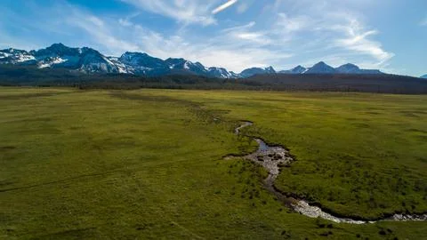 A large, open field with a river running through it Foto stock