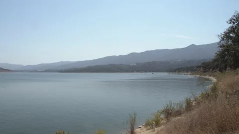 Large Open Lake and Mountains In The Backdrop - Rippling Water Stock Footage 152798757