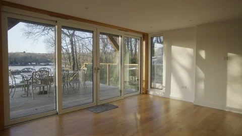 A large open living room with a view of a lake Stock Footage 302441758