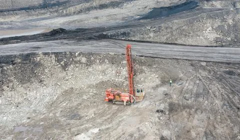 Large open-pit coal mine operation with heavy machinery and drilling equipment Stock Photos