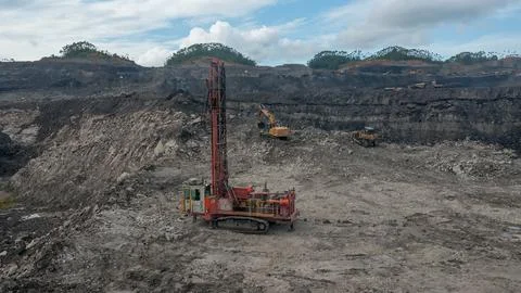 Large open-pit coal mine operation with heavy machinery and drilling equipment Stock Photos