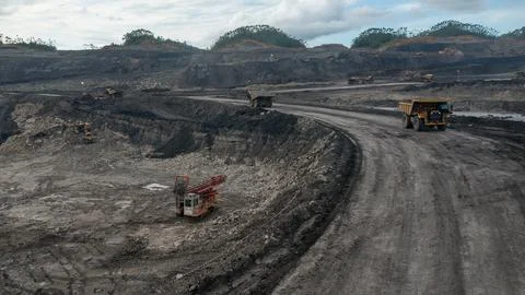 Large open-pit coal mine operation with heavy machinery and drilling equipment Foto stock