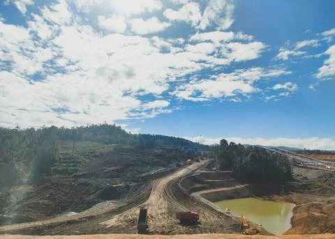 Large Open-Pit Mine with Heavy Machinery, Winding Road, and Industrial Facility Stock Photos