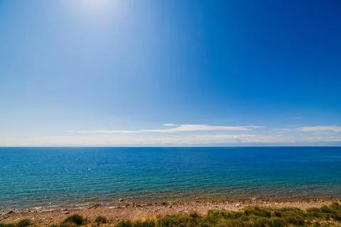 Large open water surface with far snowcapped mountain range on the horizon and Фото