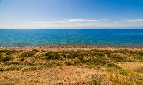 Large open water surface with far snowcapped mountain range on the horizon and Stock Photos