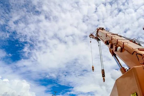 Large orange crane with a white cloud background of blue sky Stock Photos