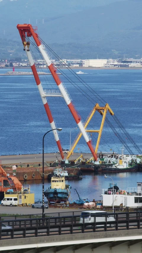 Large orange floating crane and tugboats in a port, Hakodate, Japan, 2026.09.10. 動画素材 345441529