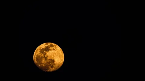 Large orange full moon moving across the dark night sky Stock Footage 347864863