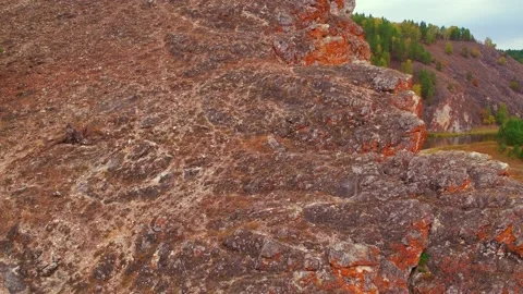 A large orange rock rises above the surface of the water. Two bright green Stock Footage 155000442