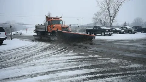 Large Orange Snow Plow Pushing Snow and Ice in Parking Lot Winter Video stock 148704350