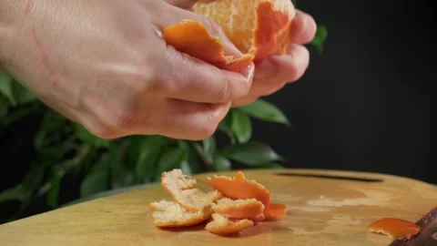 Large orange tangerines lie on a board against a background of green leaves Stock Footage 264324497