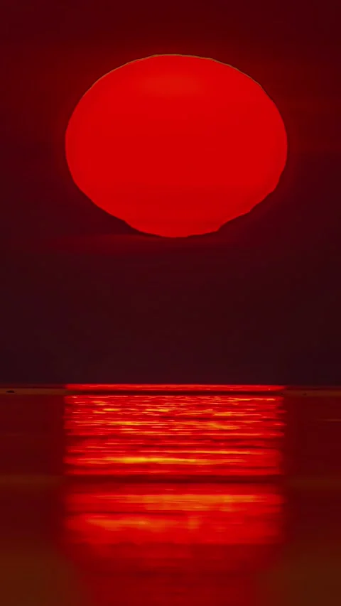 Large orangish sun setting in a horizon of sea. Timelapse shot. Stock Footage 317624092
