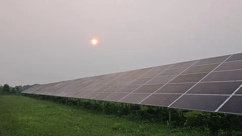 Large outdoor solar panel array with glowing red sun overhead Stock Footage 249643535
