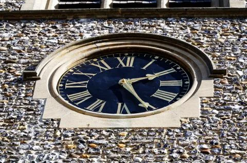 A large outside clock shows the time at twenty-five past two Stock Photos