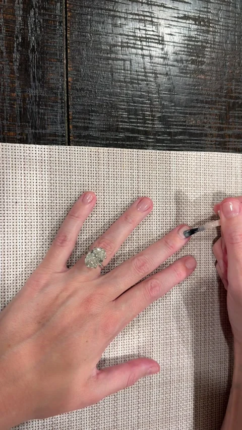 Large oval diamond engagement ring while painting nails with neutral polish Video stock 325876848
