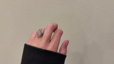 Large oval diamond solitaire engagement ring on hand simple neutral scene Stock Footage 325876980