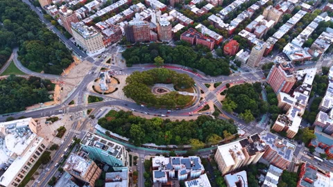 Large oval traffic circle surrounded by lush green trees and dense city blocks. 動画素材 344602944