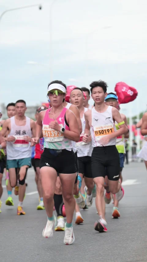 Large Pack of Marathon Runners Approaching with Pink Pace Balloons 스톡 동영상 348071126
