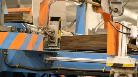 Large packs of sheets of cardboard are fed into the machine for the production Stock Footage 144587282
