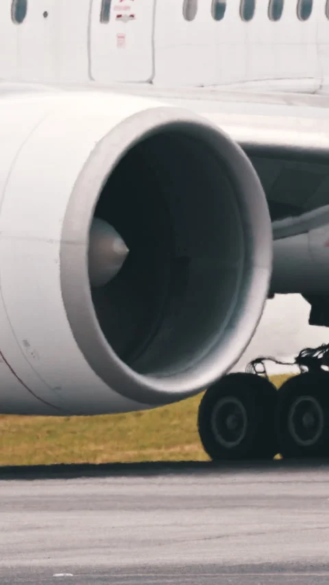 Large passenger airplane engine and landing gear taxiing on runway Stock Footage 327637911