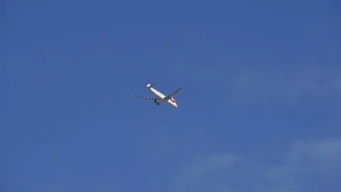 Large passenger airplane flying overhead into clouds Stock Footage 77429344