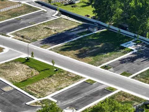 A large patch of land surrounded by trees and grass in the middle of a road Fotos de archivo