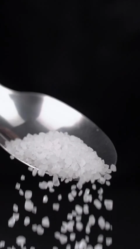 Large pea of coarse salt falls off the spoon during cooking. 動画素材 281660496