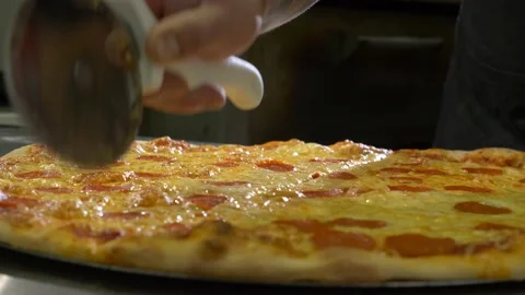 Large pepperoni pizza sliced up by chef in kitchen 4K Stock Footage 192463282