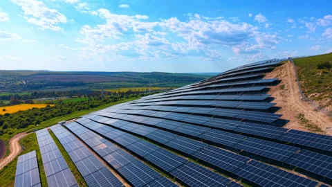 Large photovoltaic array on a hillside surrounded by farmland. Diagonal rows of Stock Footage 336386655