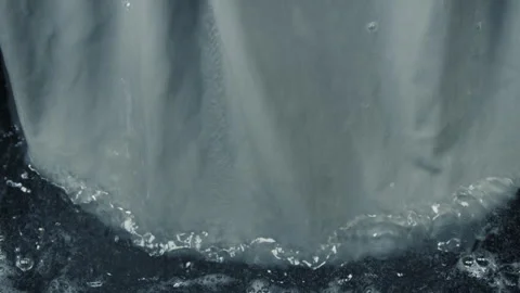 A large piece of grey fabric is removed from the liquid. Slow motion Stock Footage 263199338