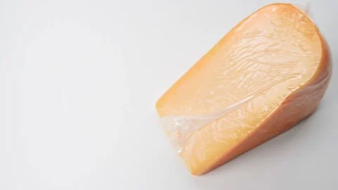 Large piece of hard cheese in package on white background. Fresh tasty cheese Stock Footage 170724169