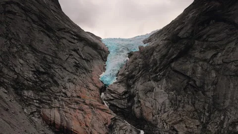 Large piece of ice melting into small river in mountains Stock Footage 255734017