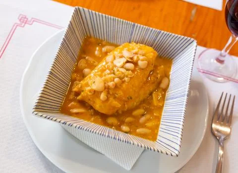 Large piece of lean cod fillet stewed in bean gravy Stock Photos
