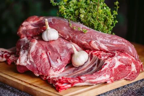 A large piece of meat on a stone table. Stock Photos