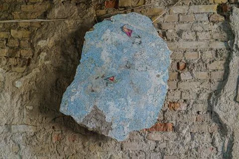 Large piece of plaster hanging on a brick wall Stock Photos